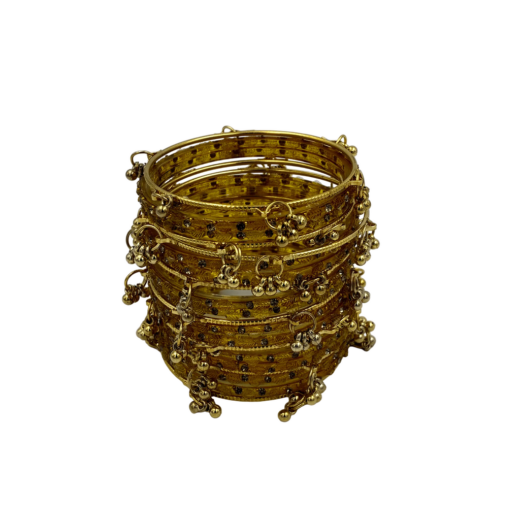 Stack of gold bangles with intricate designs on a white background