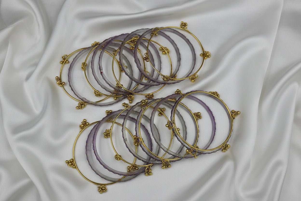Set of gold and purple bangles on a white background