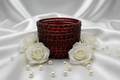 Decorative glass vase with beaded design on a white background