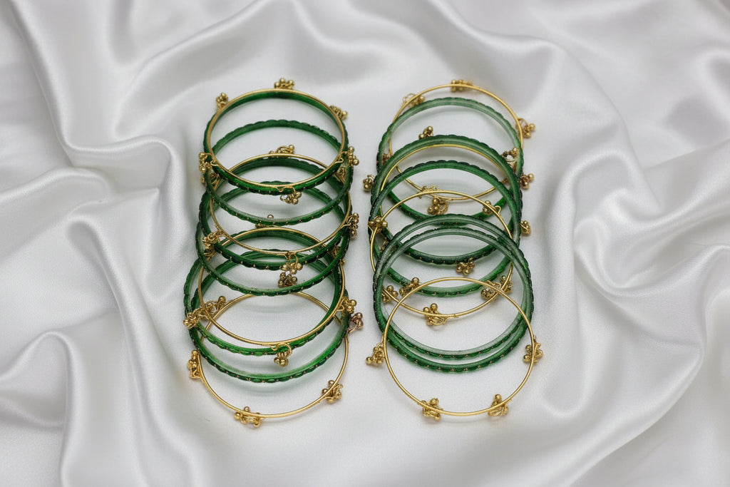 Set of green bangles with gold accents on a white background