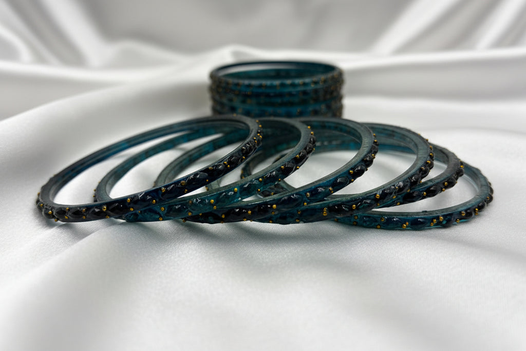 Set of blue bangles with gold accents on a white background