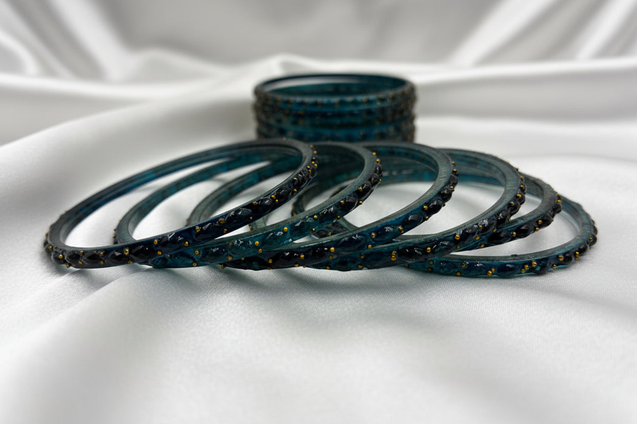 Set of blue bangles with gold accents on a white background